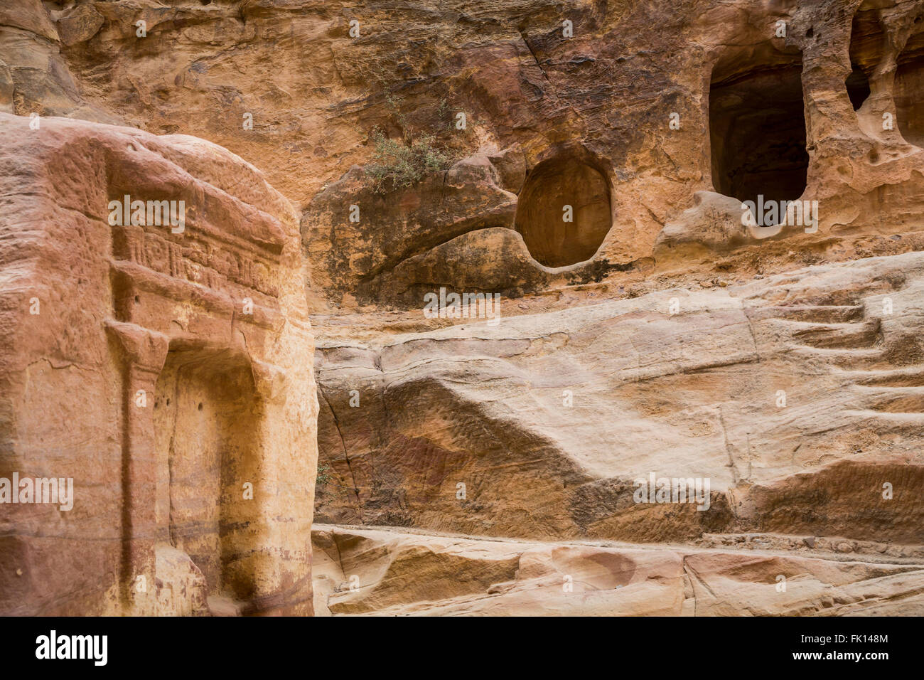 Tombe intagliate e le grotte di Siq passaggio all'ingresso di Petra, Regno Hascemita di Giordania, Medio Oriente. Foto Stock