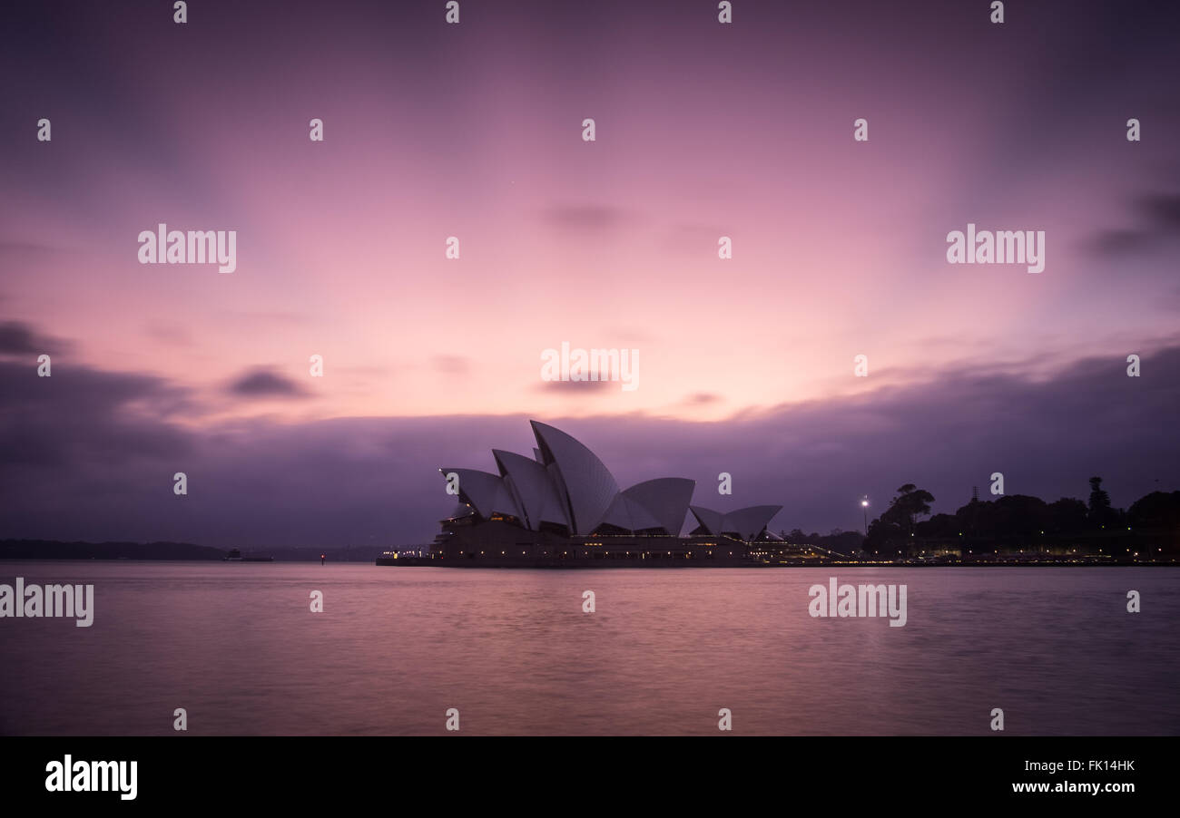 Nuvole all'orizzonte creare strisce a Alba sul Porto di Sydney e il Sydney Opera House Foto Stock
