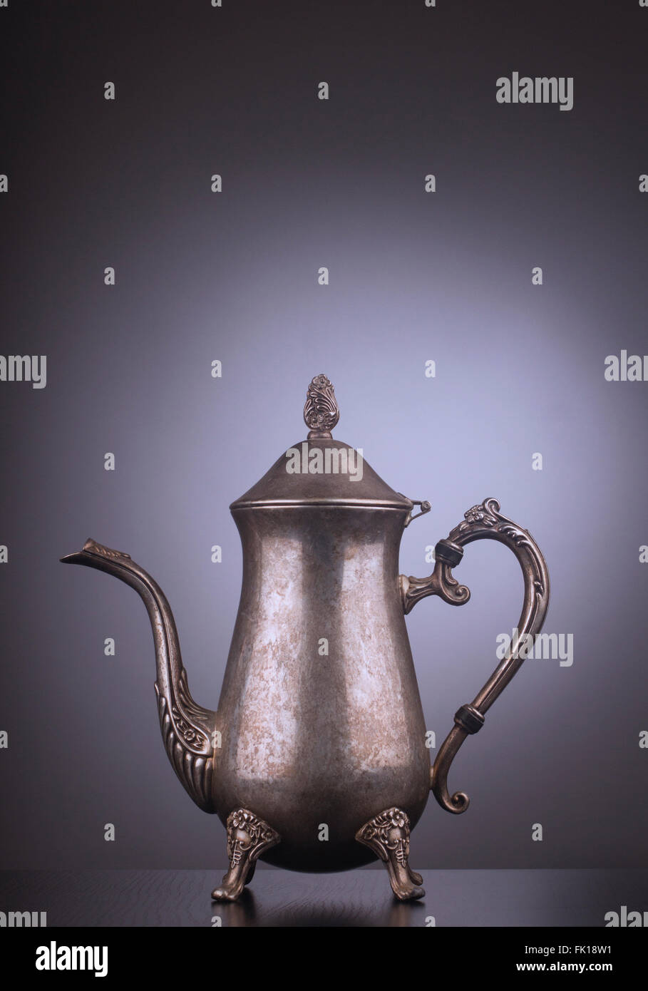 Argento vintage bollitore per il tè con incisioni su sfondo grigio Foto Stock