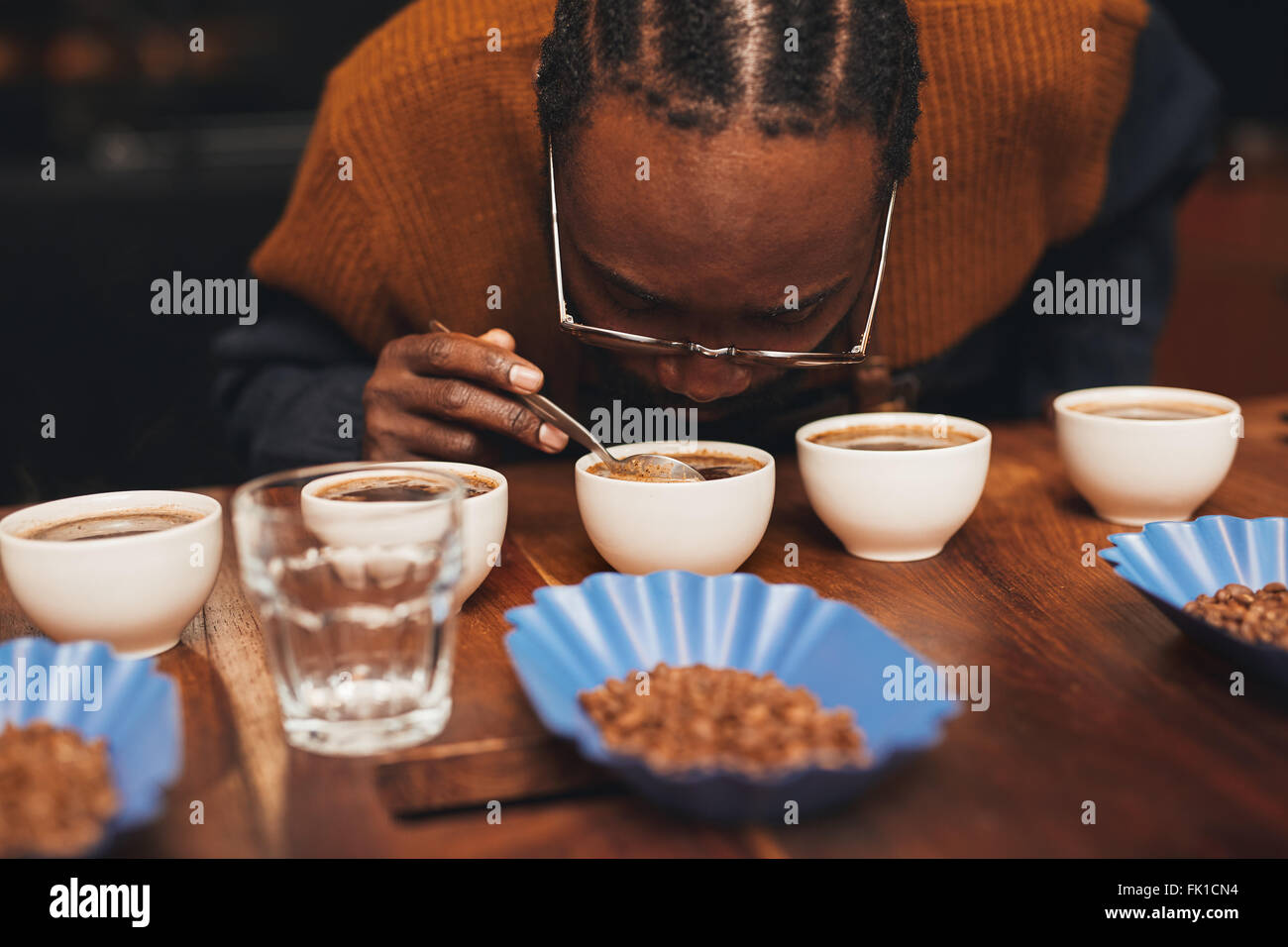 L'uomo africano Annusare il profumo del caffè a una degustazione Foto Stock