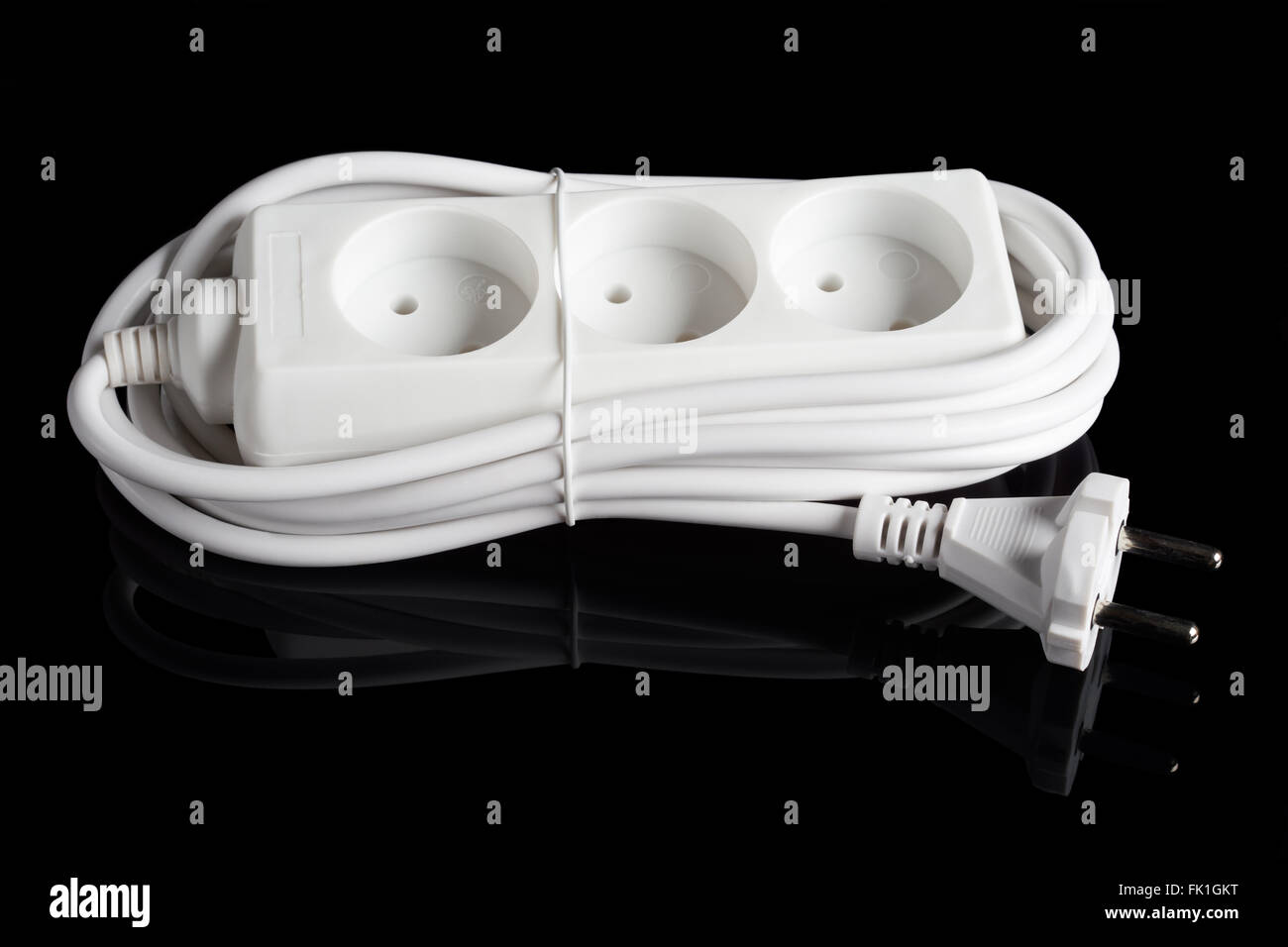 In plastica bianca presa elettrica estensione isolato nero su sfondo riflettente Foto Stock