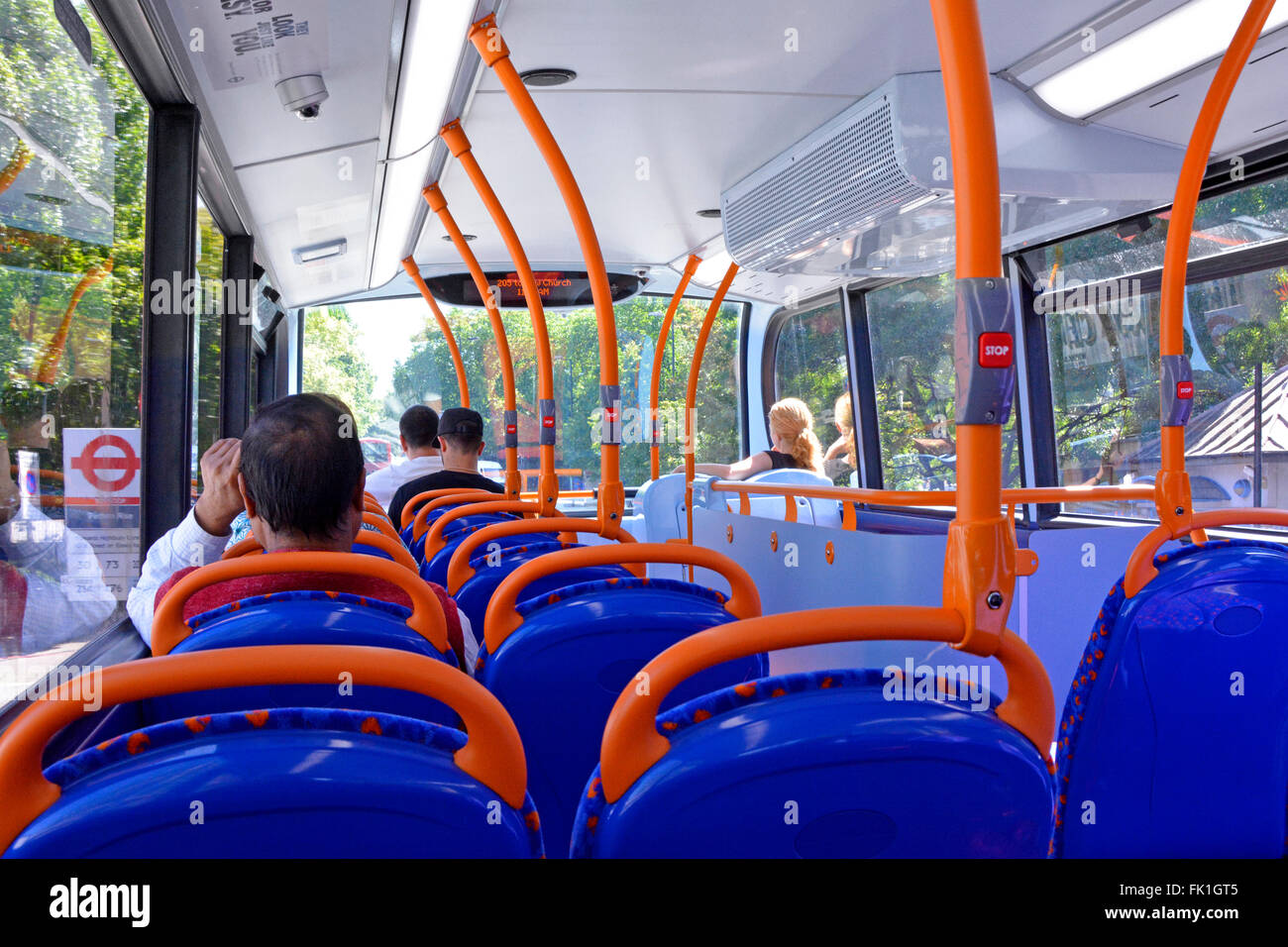 London bus interno di passeggeri seduti sul ponte superiore del double decker bus in attesa presso la fermata segno visibile attraverso la finestra England Regno Unito Foto Stock