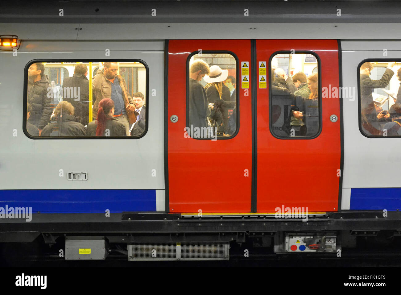La metropolitana di Londra affollato treno trasporto di cerchio in piedi di tubo di linea passeggeri pendolari nelle ore di punta Foto Stock