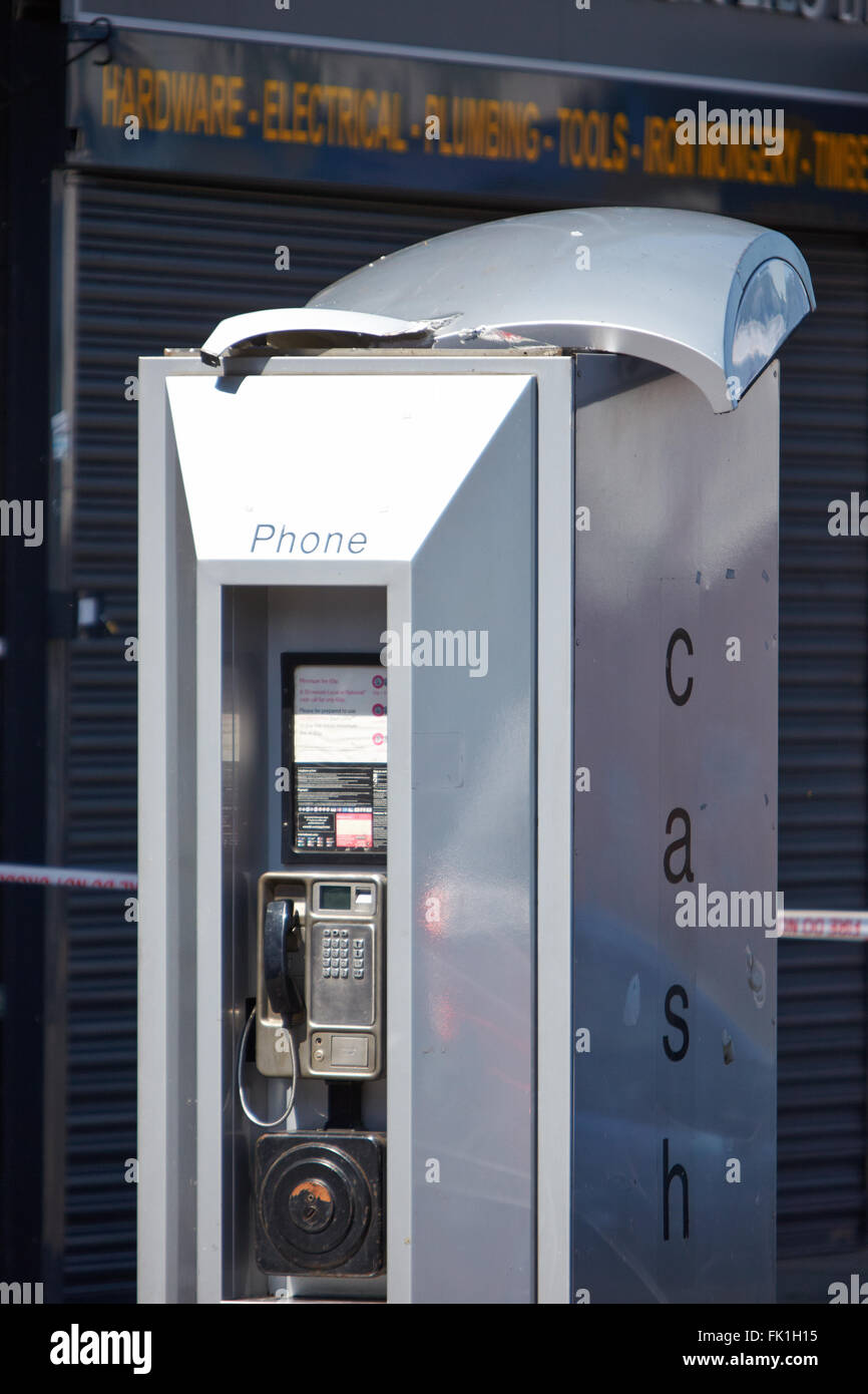 Una casella Telefono , con un tetto danneggiato, davanti alla scena di un incendio mortale a Hounslow. Foto Stock