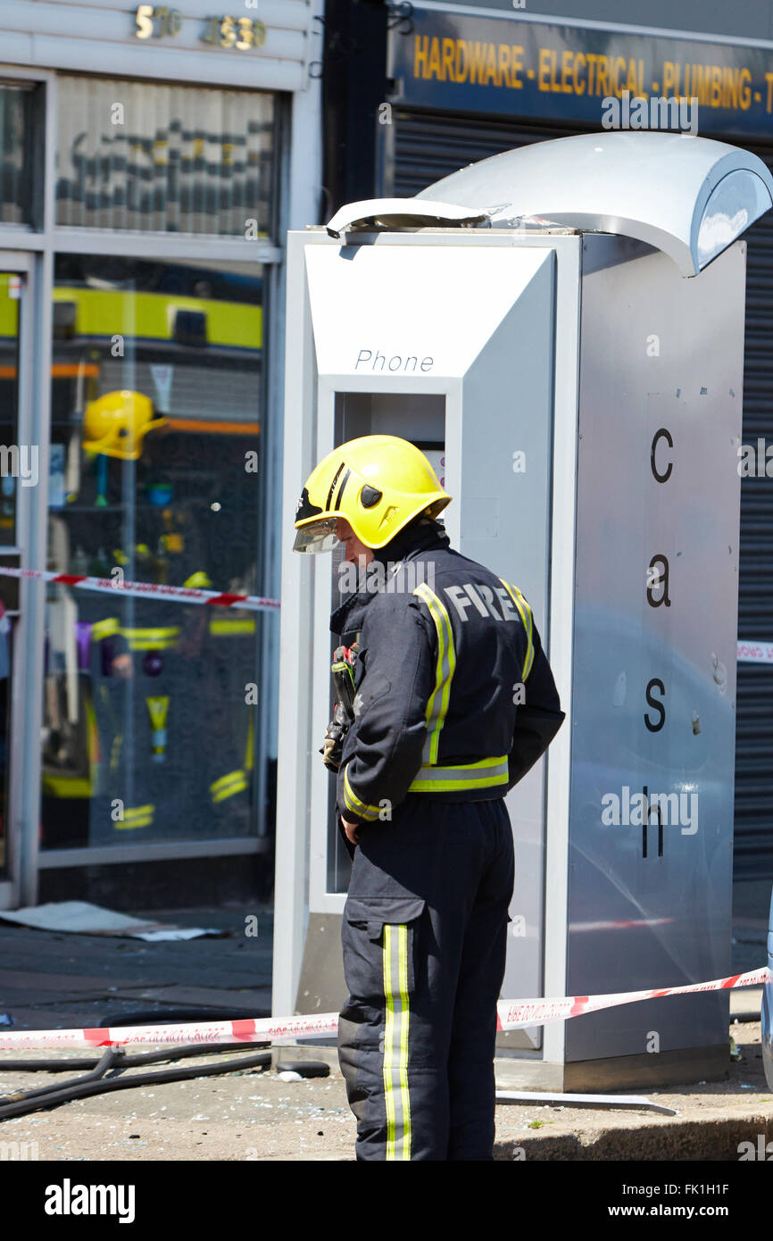 Una casella telefono, con un tetto danneggiato, davanti alla scena di un incendio mortale a Hounslow. Foto Stock