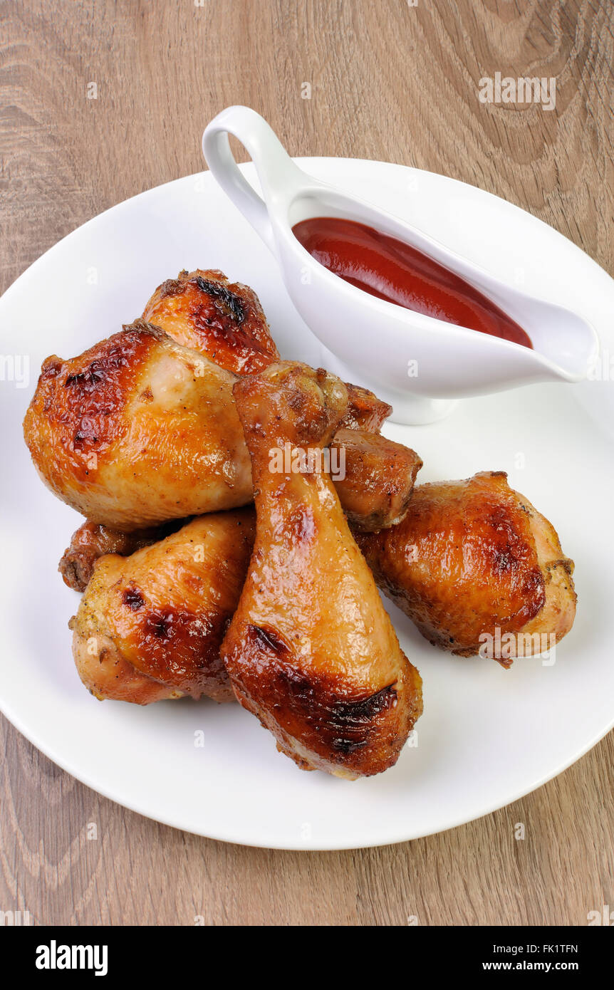 Il pollo al forno della gamba con salsa di pomodoro su una piastra Foto Stock