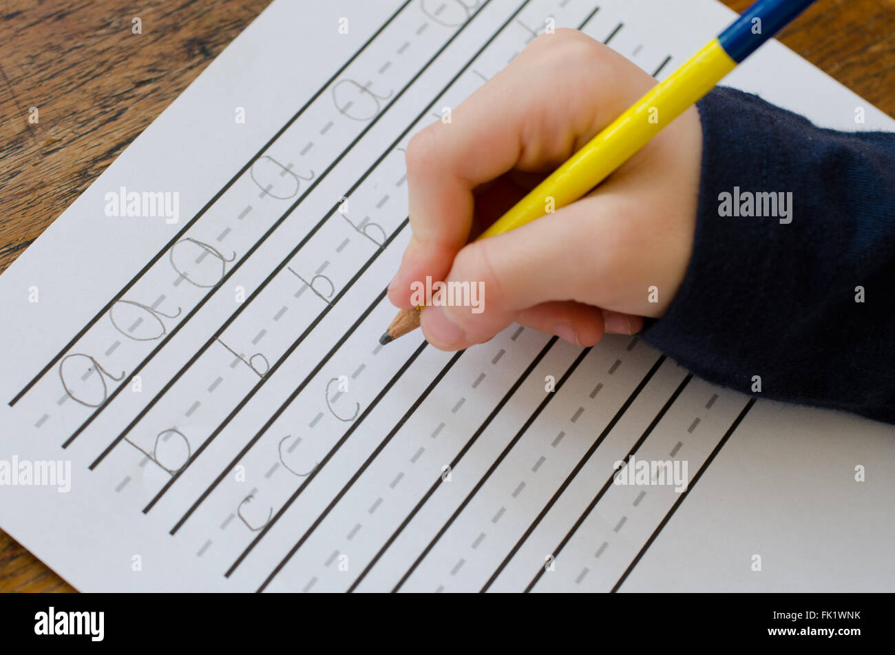 La scrittura di abc, un bambino mano che tiene una matita e mostrando loro la pratica di scrivere le loro lettere. Foto Stock