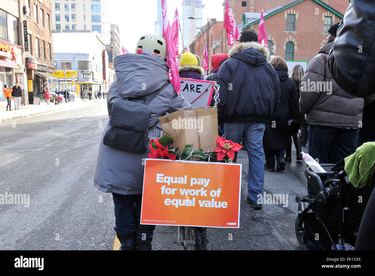 Toronto, Canada. Il 5 marzo 2016. La Giornata internazionale della donna Toronto 2016 marzo svoltasi presso il centro cittadino di Toronto. Nella foto, marcher bicicletta visualizza un "Parità di retribuzione per lavori di pari valore" di segno. Credito: EXImages/Alamy Live News Foto Stock