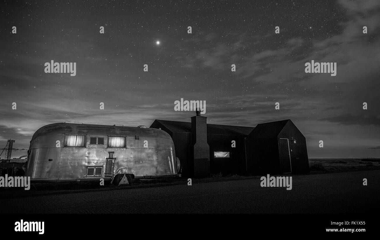 Nero in gomma casa da Simon Conder con la camera degli ospiti roulotte Airstream a Dungeness Kent England. Foto Stock