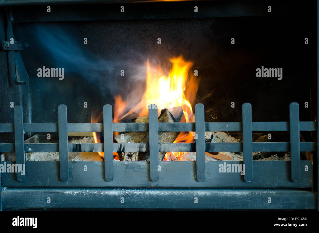 Camino costituito da fuoco a bruciare in una griglia di metallo Foto Stock