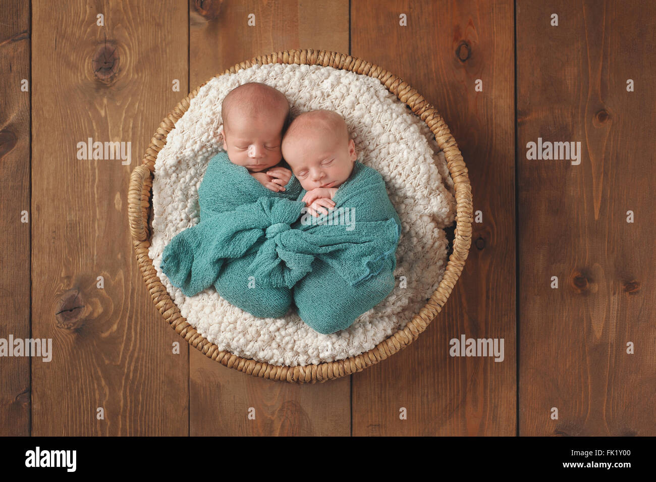 Neonato twin baby boys dormire in un cesto di vimini. Foto Stock