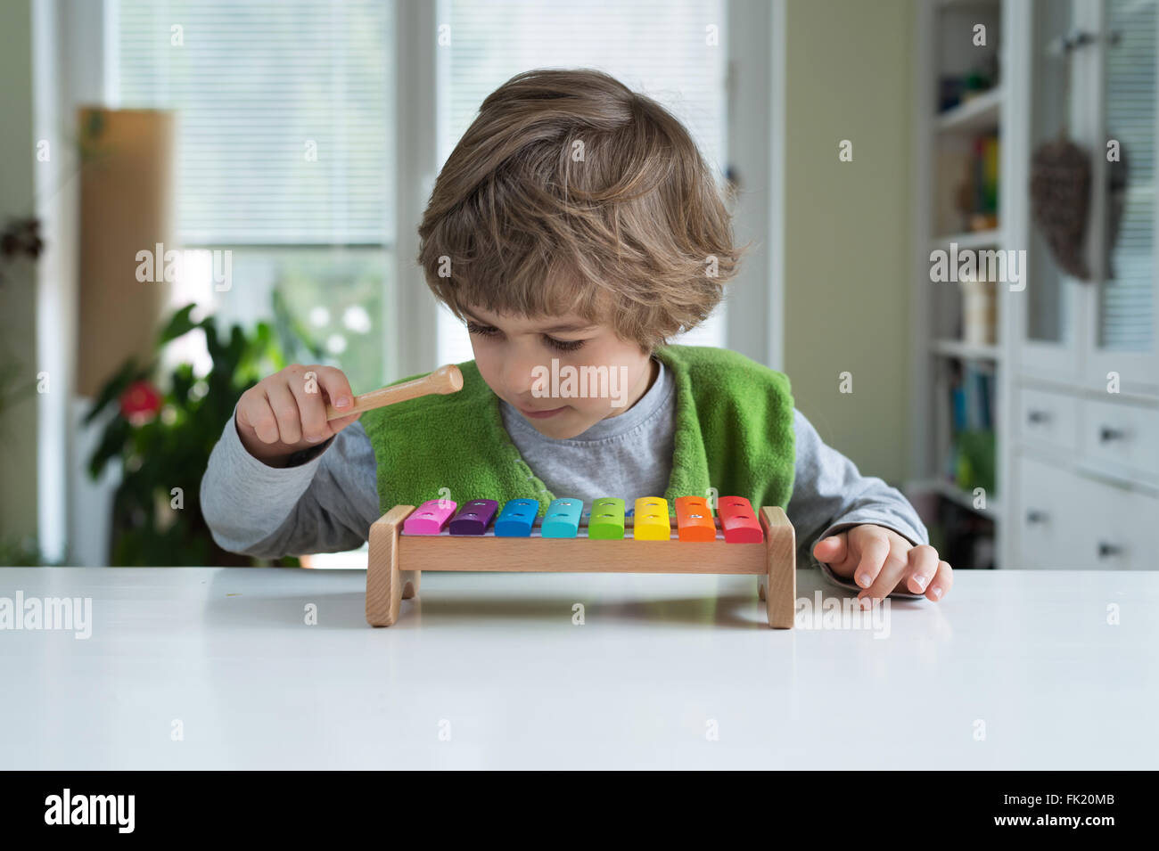 Carino piccolo giocando su xilofono. Educazione musicale, aiutare a riconoscere i talenti musicali, appoggiare e incoraggiare la creatività dei bambini Foto Stock