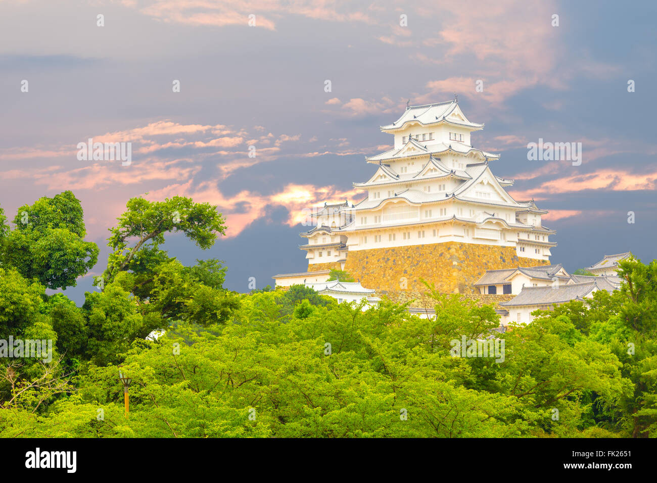 Bel tramonto dietro recentemente rinnovato Himeji-jo il Castello sopra le cime degli alberi visto da una distanza di Himeji, Giappone dopo 2 Foto Stock