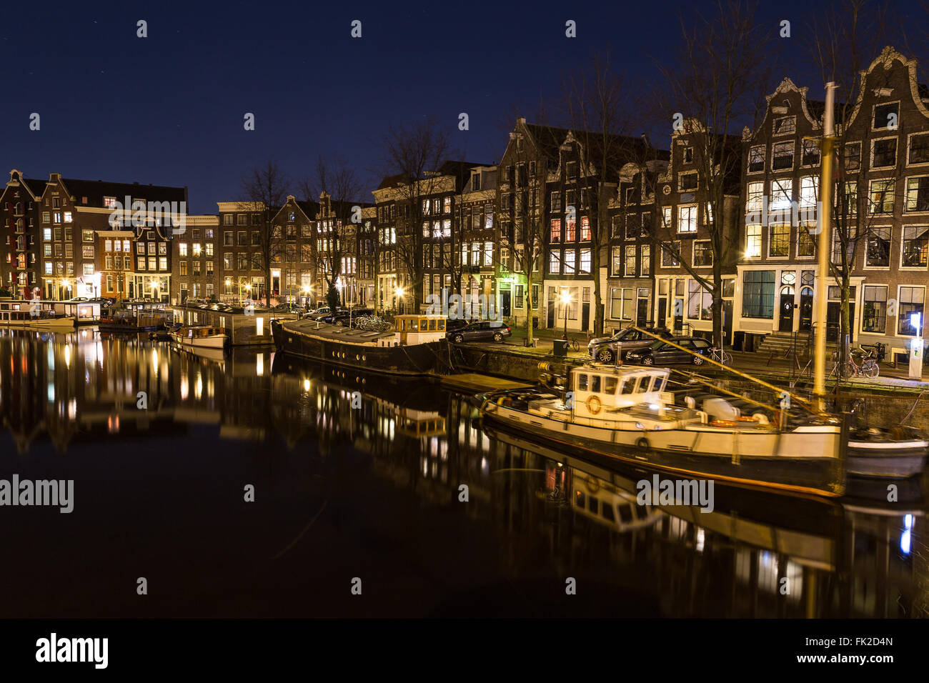 Una vista lungo il canale Waalseilandgracht ad Amsterdam di notte. Edificio, barche e riflessioni può essere visto. Vi è spazio per Foto Stock