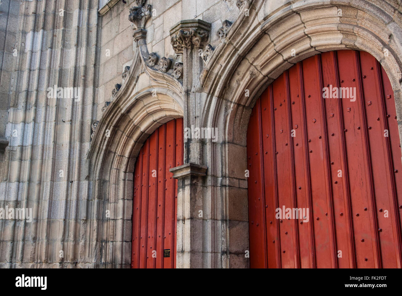 Una coppia di porte rossa segna l ingresso in una chiesa di Rennes Foto Stock