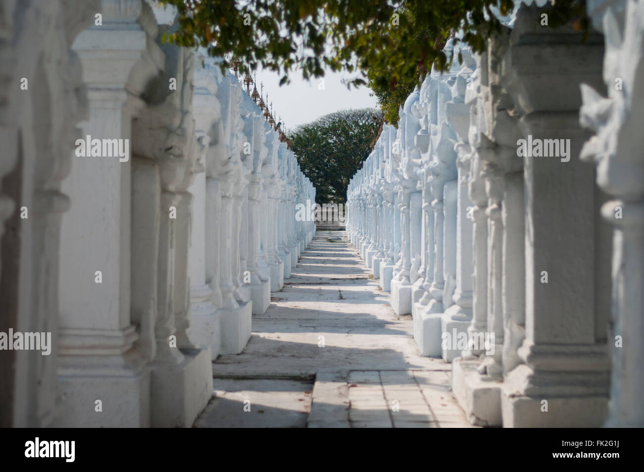 Vicolo stretto fiancheggiato da lunghe file di colonne bianche a pagoda Kuthodaw, Mandalay Myanmar (Birmania). Foto Stock