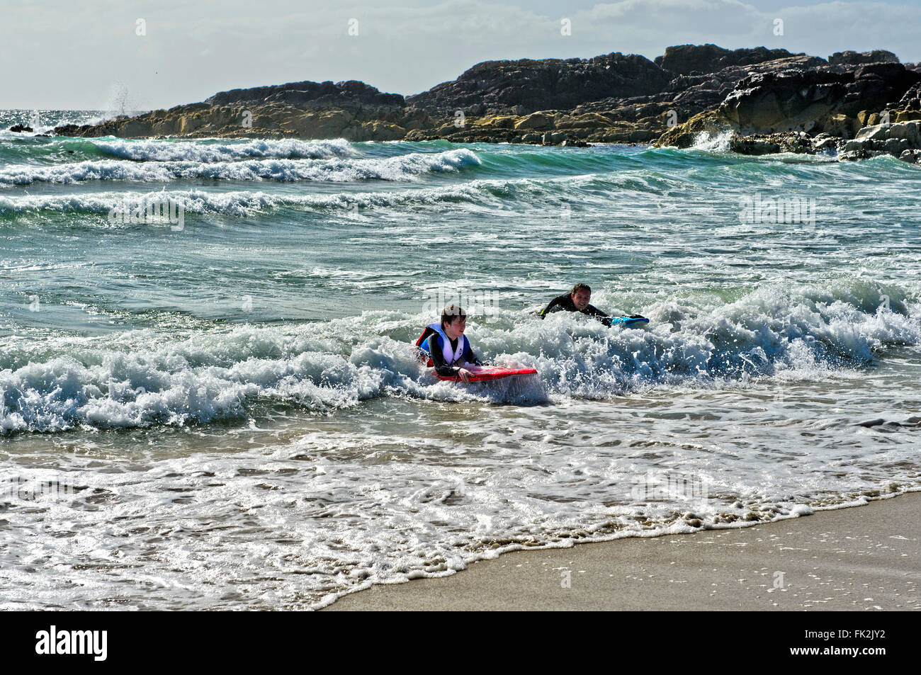 I nuotatori in surf a Clachtoll Bay, Clatchtoll, Assynt, Scotland, Regno Unito Foto Stock