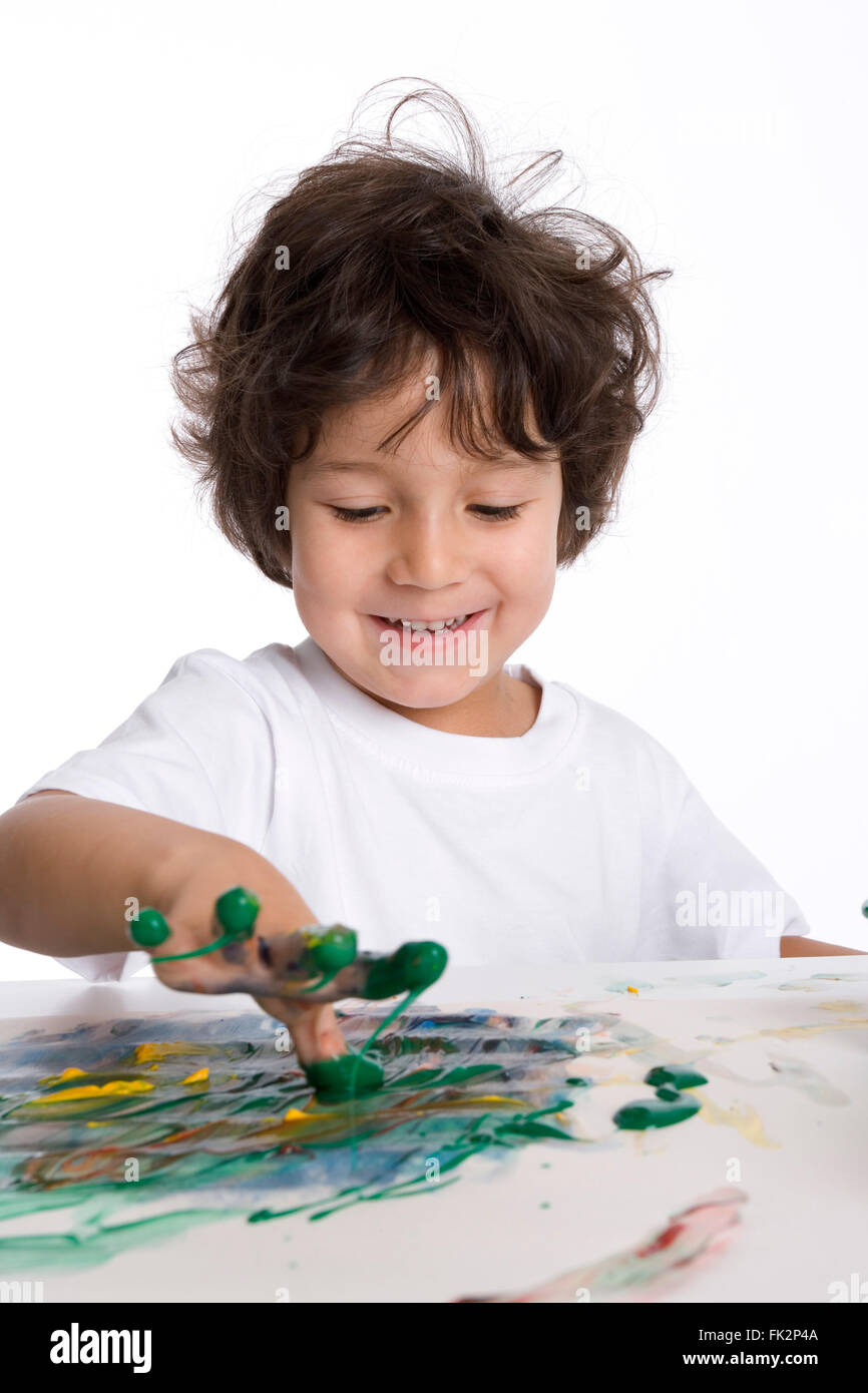 Little Boy sta compiendo un dito- dipinto su sfondo bianco Foto Stock
