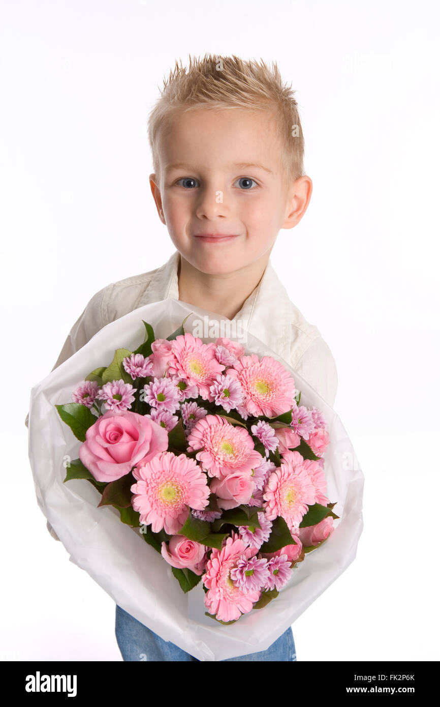 Little Boy è in possesso di un mazzo di fiori su sfondo bianco Foto Stock