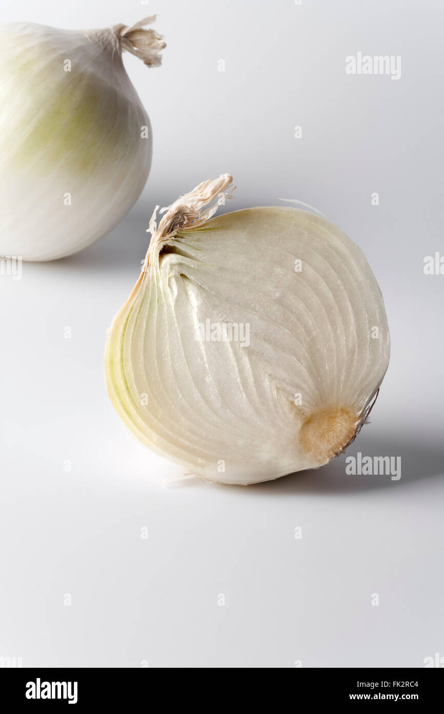 Intera e mezza cipolla bianca su sfondo bianco Foto Stock