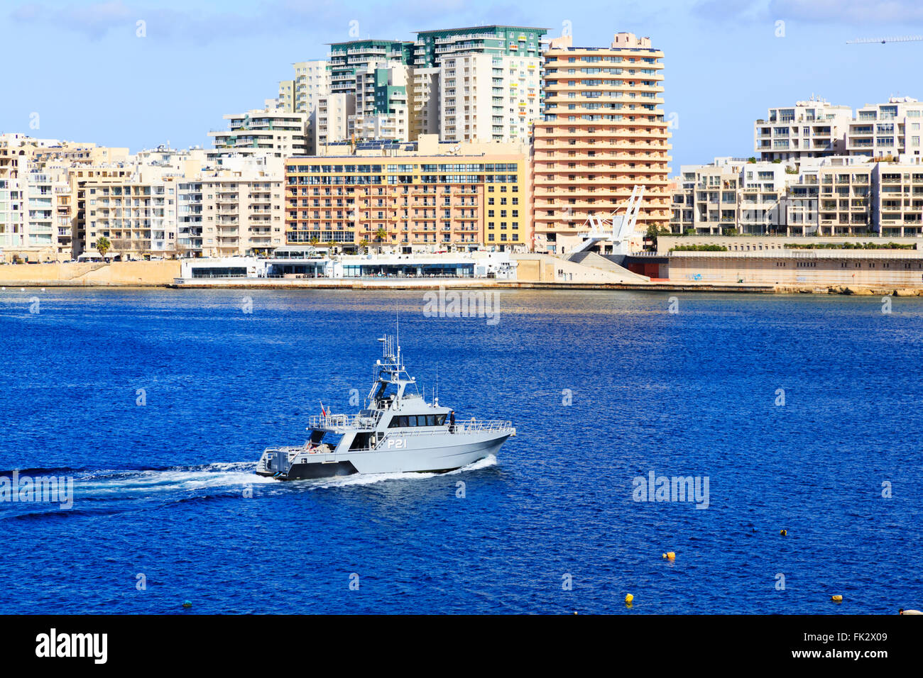 Marina militare maltese motovedetta lasciando il Grand Harbour a Sliema alberghi in background.de La Valletta, Malta Foto Stock