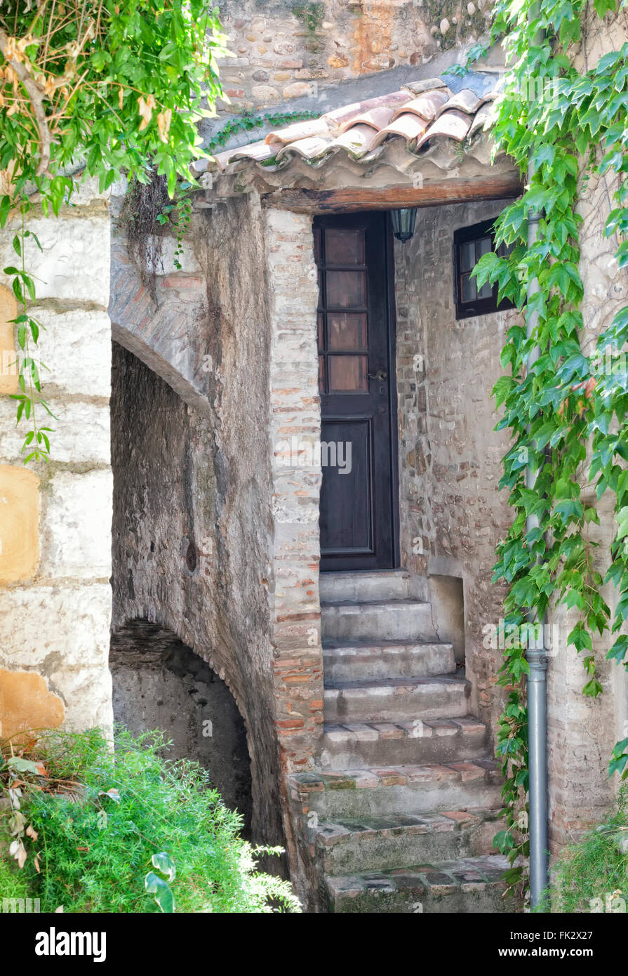 La porta anteriore di una vecchia casa di pietra nel centro storico medievale cittadina Vence in Costa Azzurra, con una scalinata, ingresso a una cantina Foto Stock