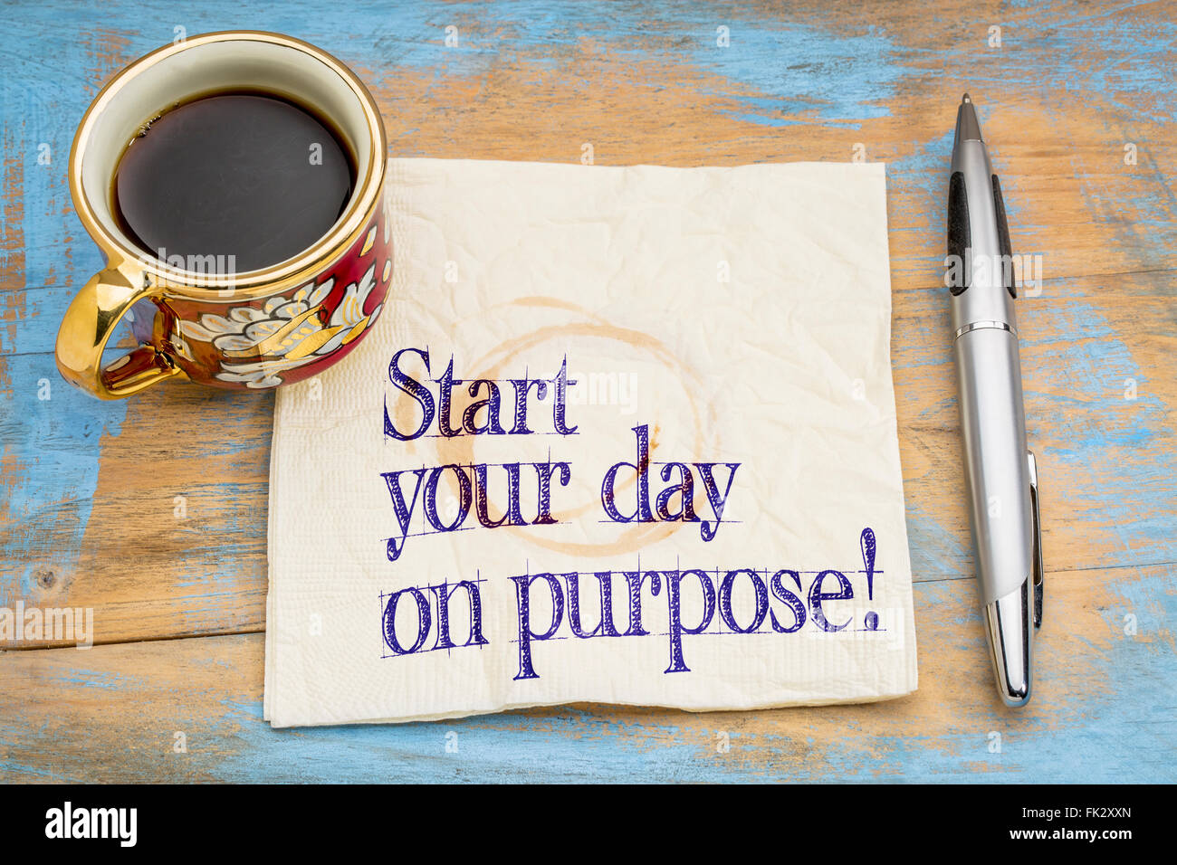 Iniziate la vostra giornata a scopo! Una consulenza motivazionale o promemoria su un tovagliolo con una tazza di caffè Foto Stock