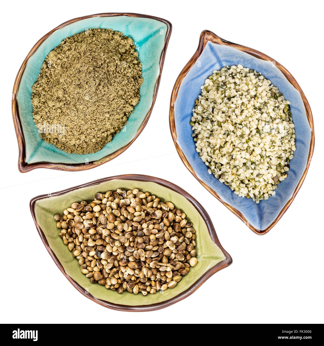 Una serie di semi di canapa, cuori e proteine in polvere, vista dall'alto di isolato a forma di foglia di coppe in ceramica Foto Stock