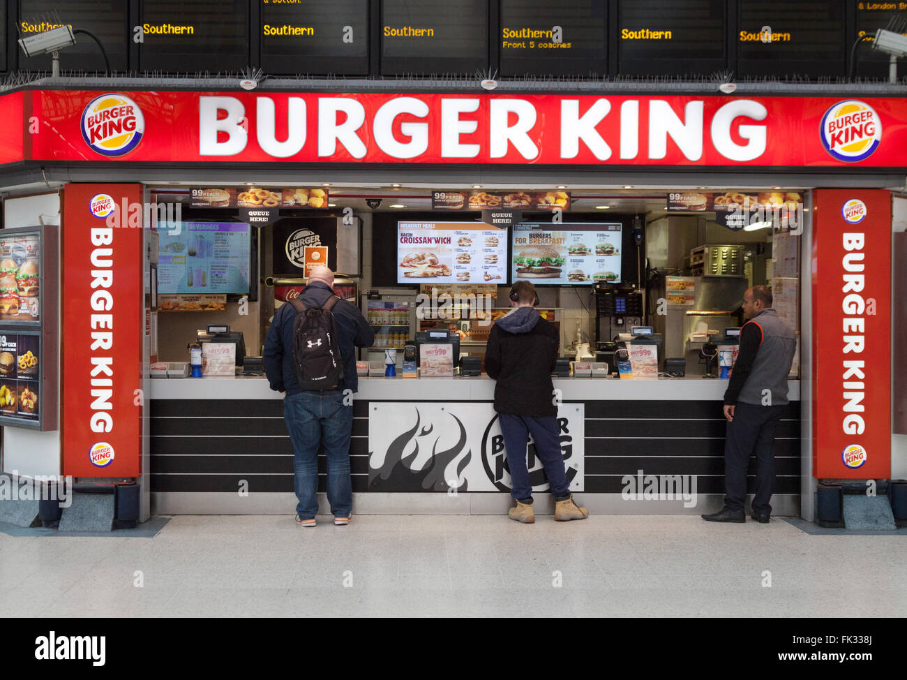 Persone che acquistano alimenti, Burger King, Victoria Station concourse, London REGNO UNITO Foto Stock