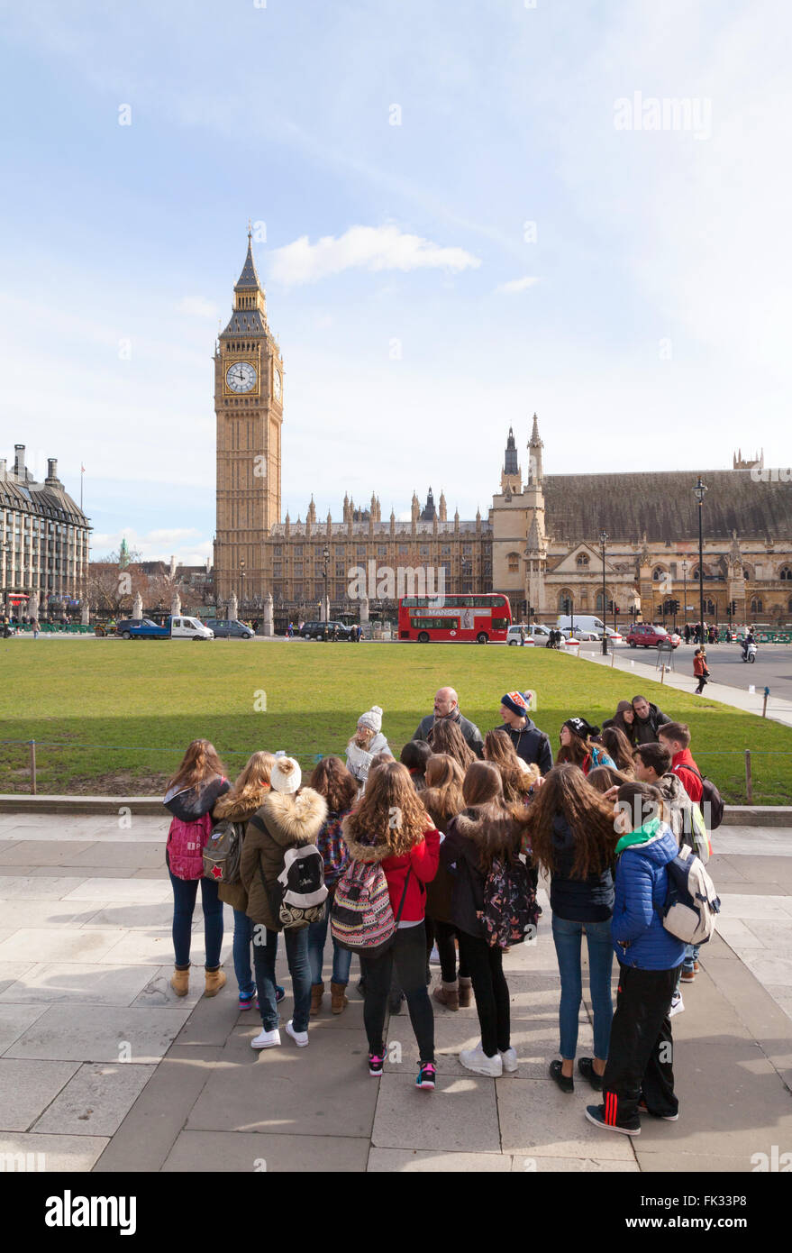 Un gruppo di bambini in gita scolastica, guardando il Big Ben, la piazza del Parlamento, London REGNO UNITO Foto Stock