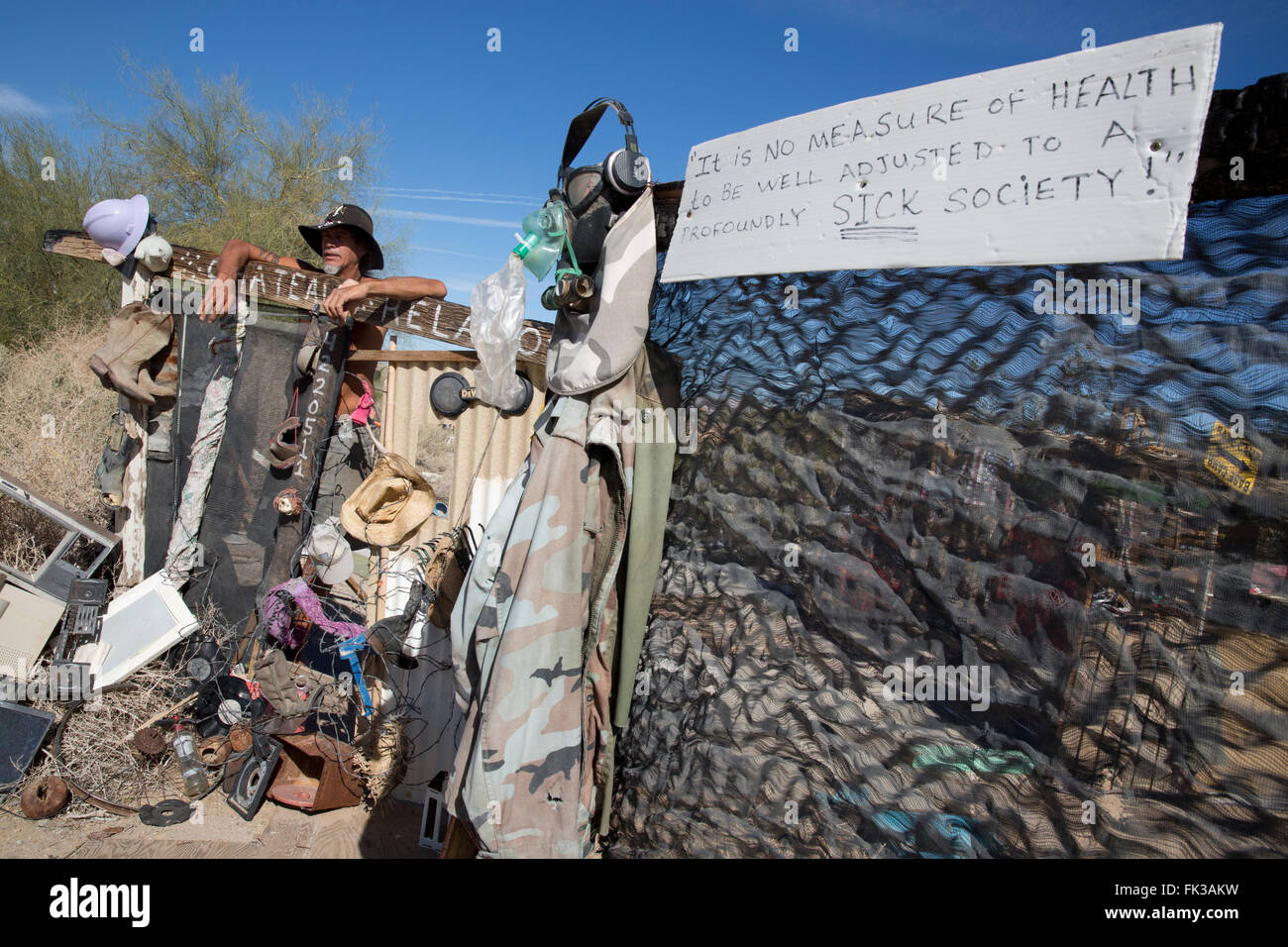 Karibe, un residente della città di Soletta, sorge in corrispondenza del cancello al suo accampamento, Niland, California USA Foto Stock