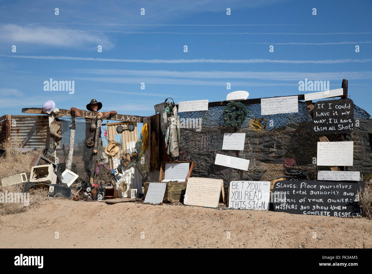 Karibe, un residente della città di Soletta, sorge in corrispondenza del cancello al suo accampamento, Niland, California USA Foto Stock