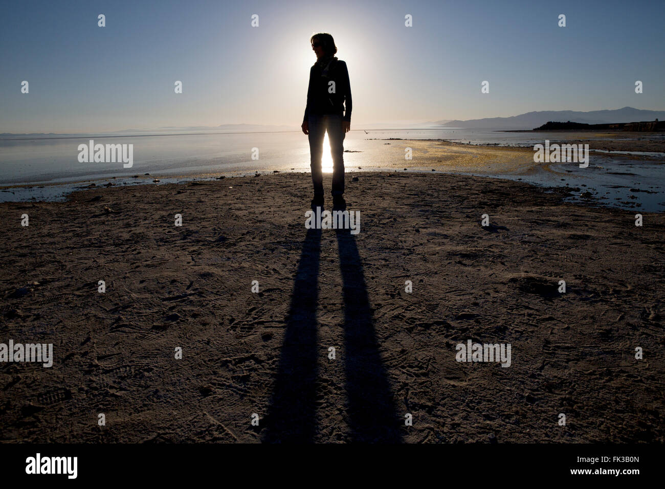 Una donna in piedi sulla riva del Salton Sea, CALIFORNIA, STATI UNITI D'AMERICA Foto Stock