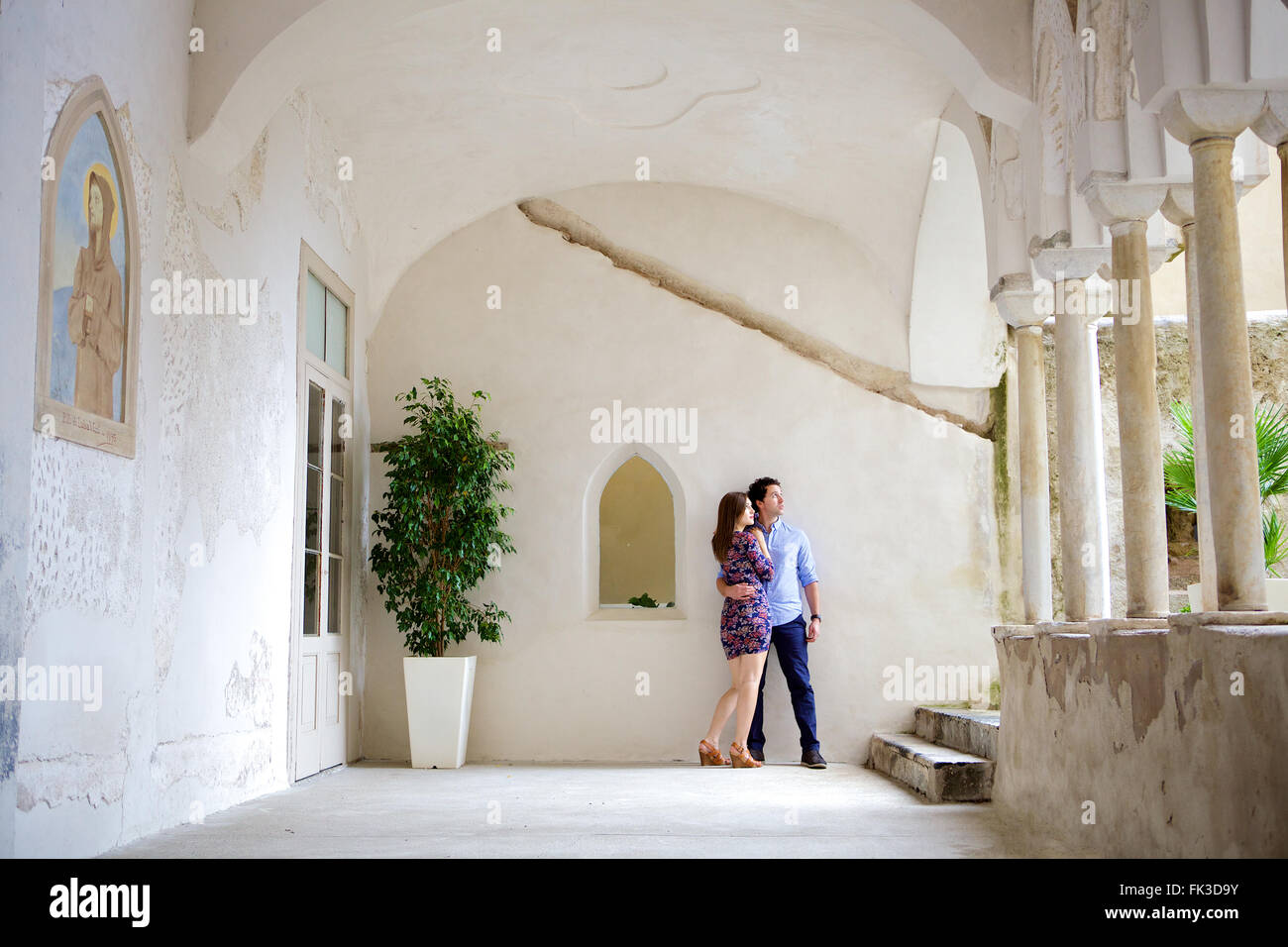 Un giovane in amore bruna giovane appoggiato nell'impostazione di una bella, vecchio edificio Mediterraneo a Costiera Amalfitana, Italia, Foto Stock