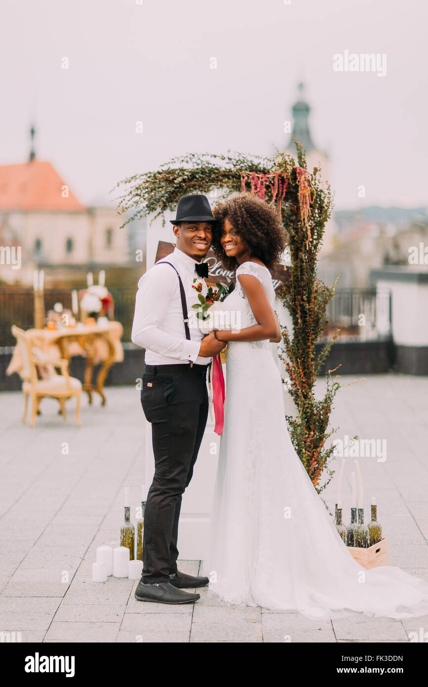 Splendide nozze nero giovane Holding Hands e sorridente sul loro weding giorno sul tetto Foto Stock