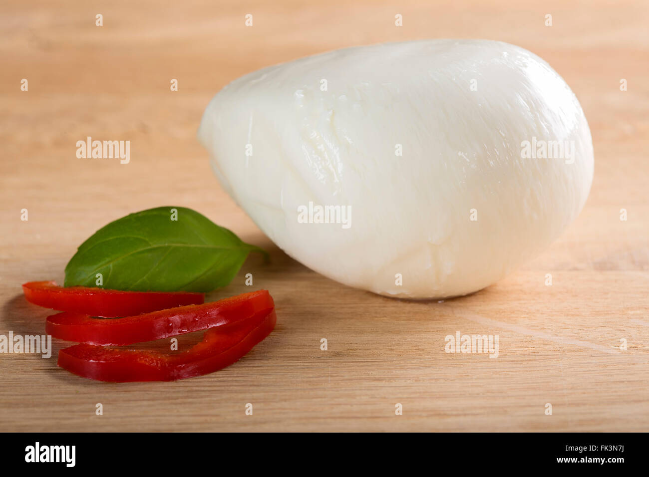 Mozzarella di bufala sul tavolo di legno con pepe rosso. Messa a fuoco selettiva. Foto Stock