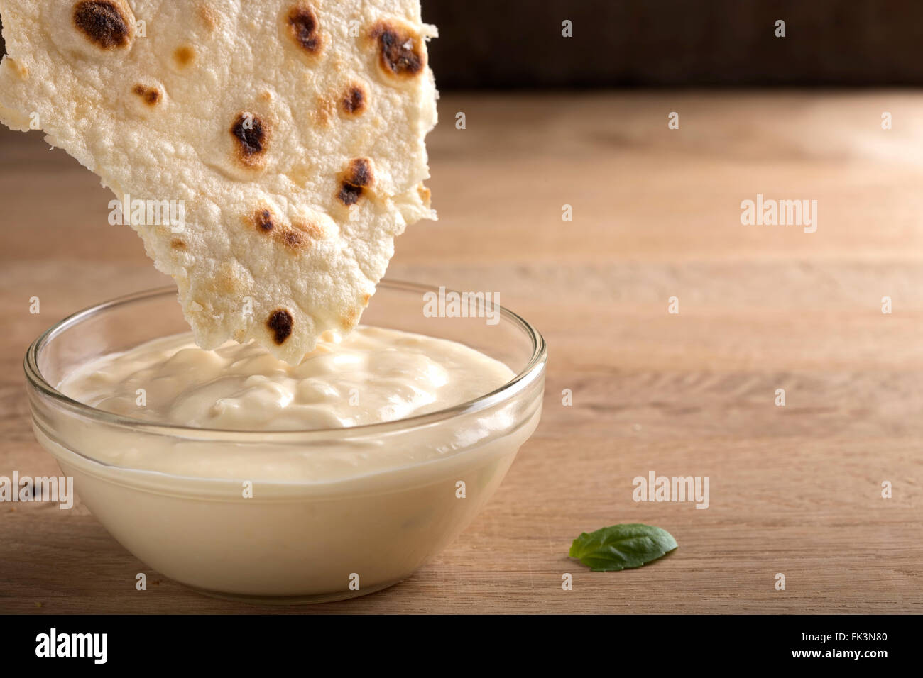 Pane Pita con tzatziki salsa di immersione su legno Foto Stock