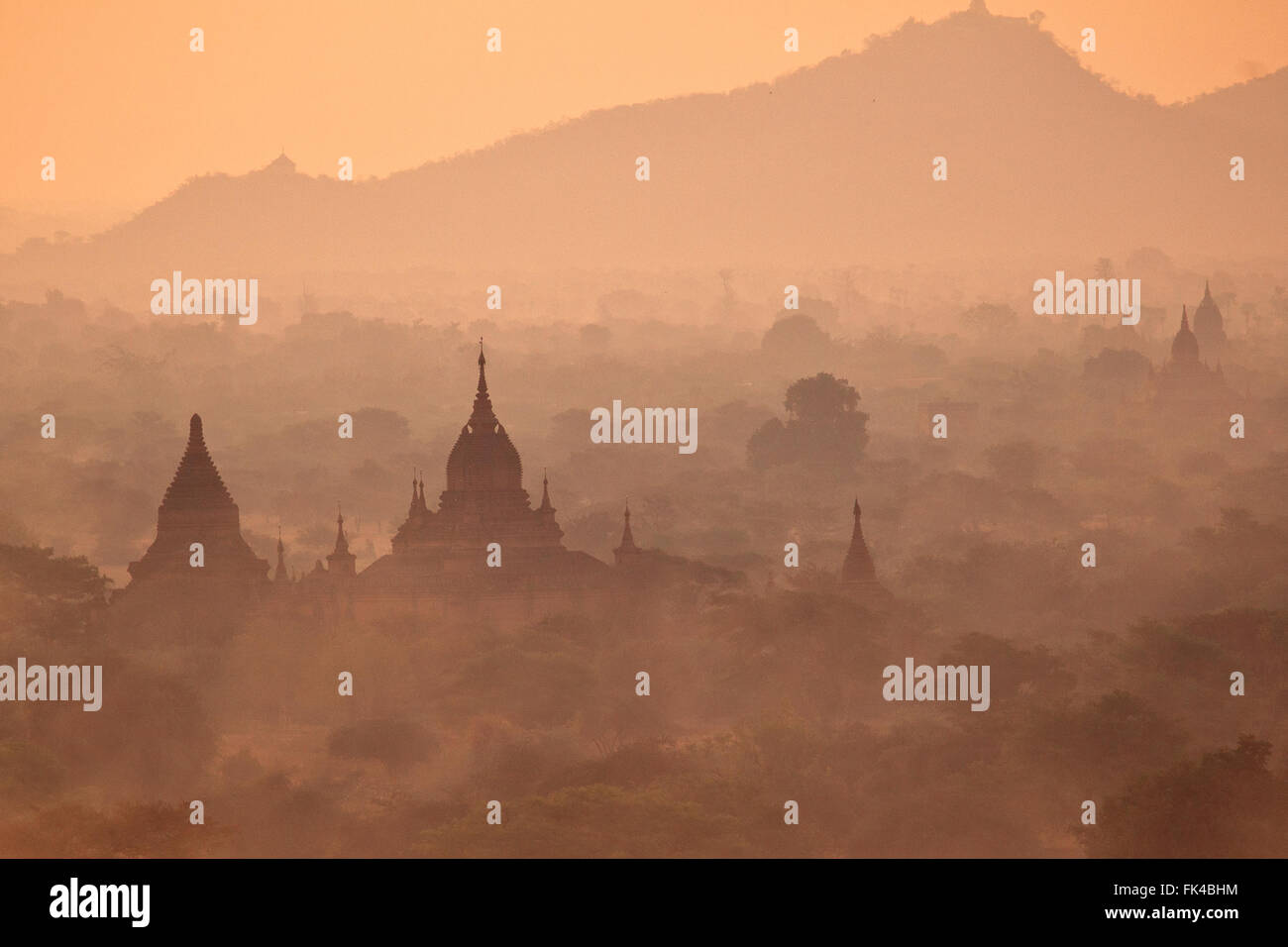 Bagan, Myanmar: templi sulla pianura incandescente nella luce della sera vicino al tramonto, l'aria molto carico con polvere e nebulosità atmosferica Foto Stock