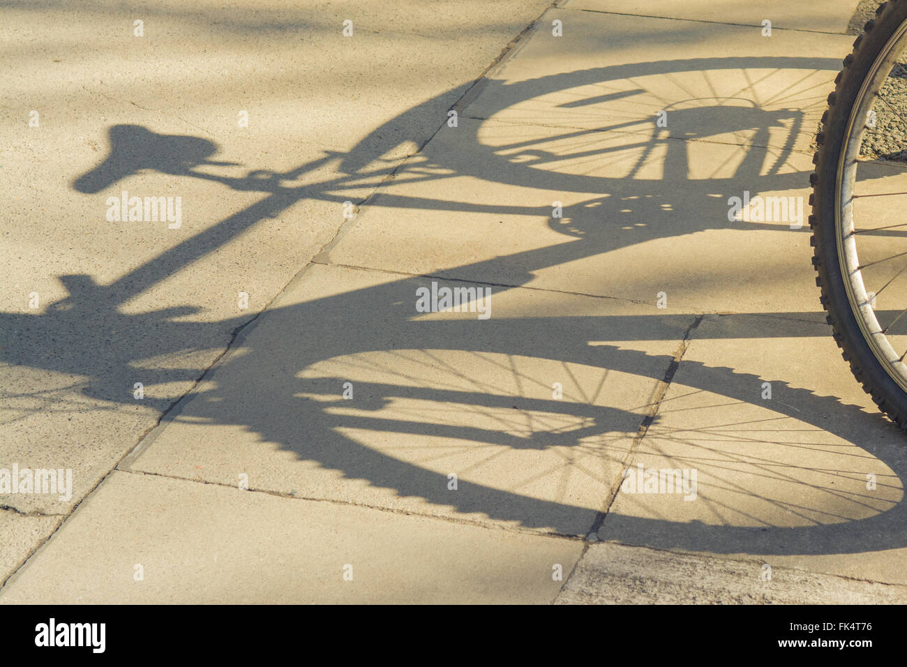 Ombra della bici sul marciapiede Foto Stock
