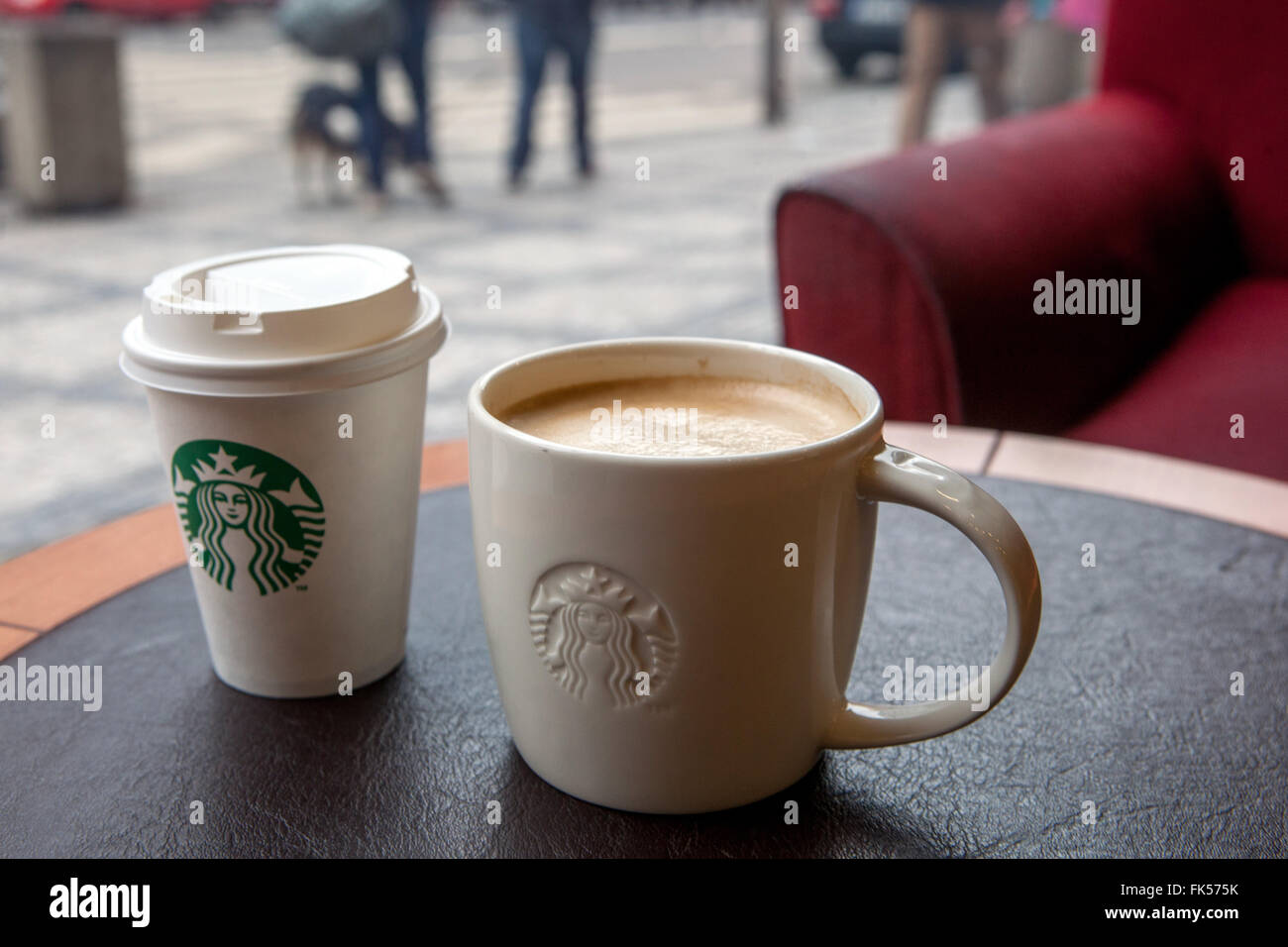 Starbucks Coffee cups su un tavolo e la strada al di fuori della finestra Foto Stock