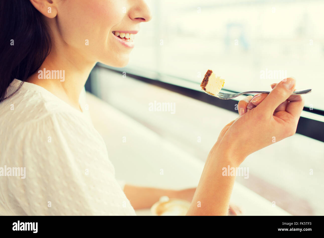 Close up della donna torta di mangiare al bar o a casa Foto Stock