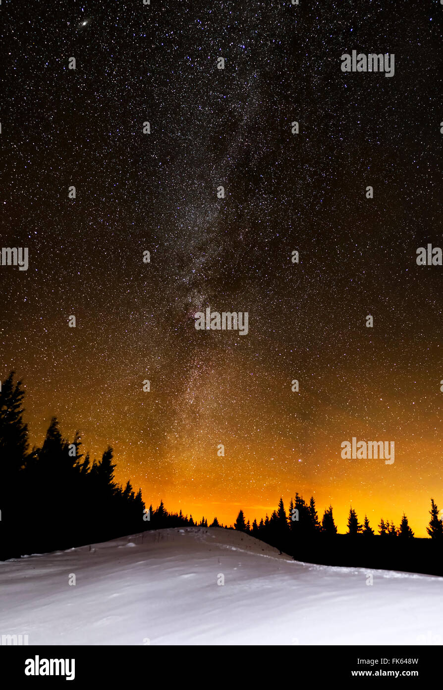 Incredibile star notte sulla collina nevoso e di abeti con la via lattea Foto Stock