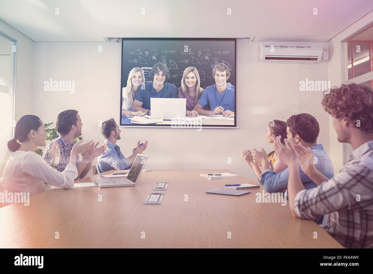 Immagine composita di un gruppo di studenti con un laptop guardare nella telecamera Foto Stock