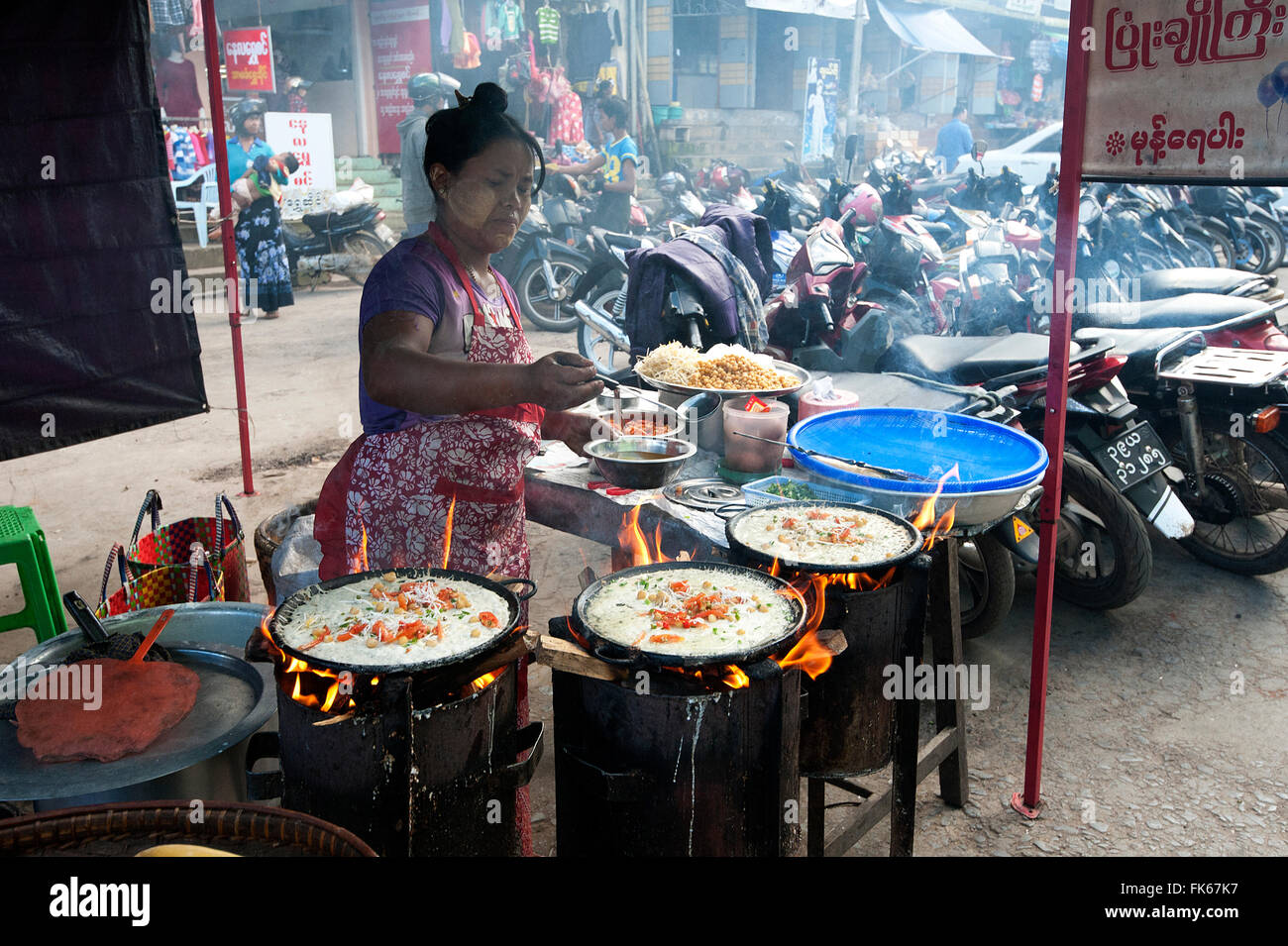 Donna friggere le frittelle di riso con riempimenti su una strada del mercato di fast food in stallo Pyin Oo Lwyn, Mandalay Division, Myanmar (Birmania) Foto Stock