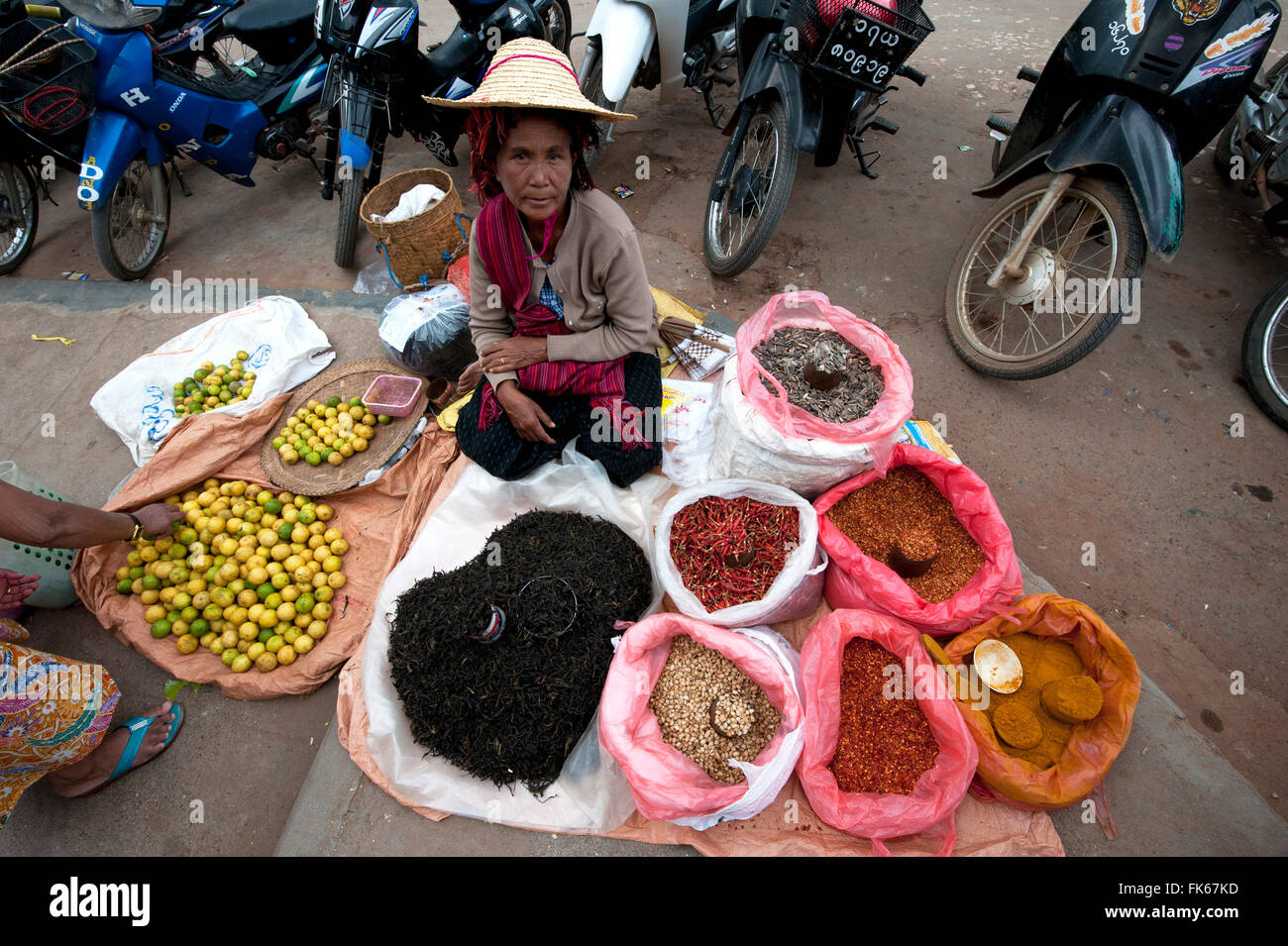 La donna nel cappello di paglia vendita di limoni, tè e spezie su una coperta fuori mercato Kalaw, stato Shan, Myanmar (Birmania), Asia Foto Stock