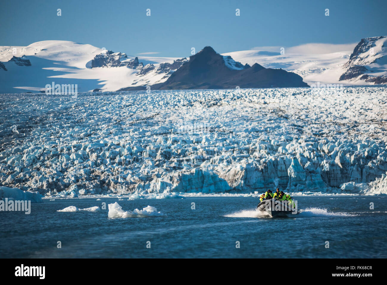 Zodiac tour in barca sul ghiacciaio di Jokulsarlon laguna, con Breidamerkurjokull ghiacciaio Vatnajokull e tappo di ghiaccio dietro, Islanda Foto Stock