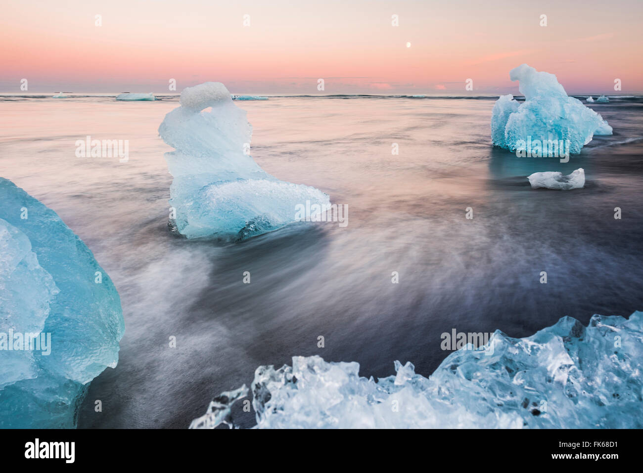 Iceberg al tramonto sulla spiaggia di Jokulsarlon, una sabbia nera vulcanica beach nel sud est dell'Islanda, Islanda, regioni polari Foto Stock