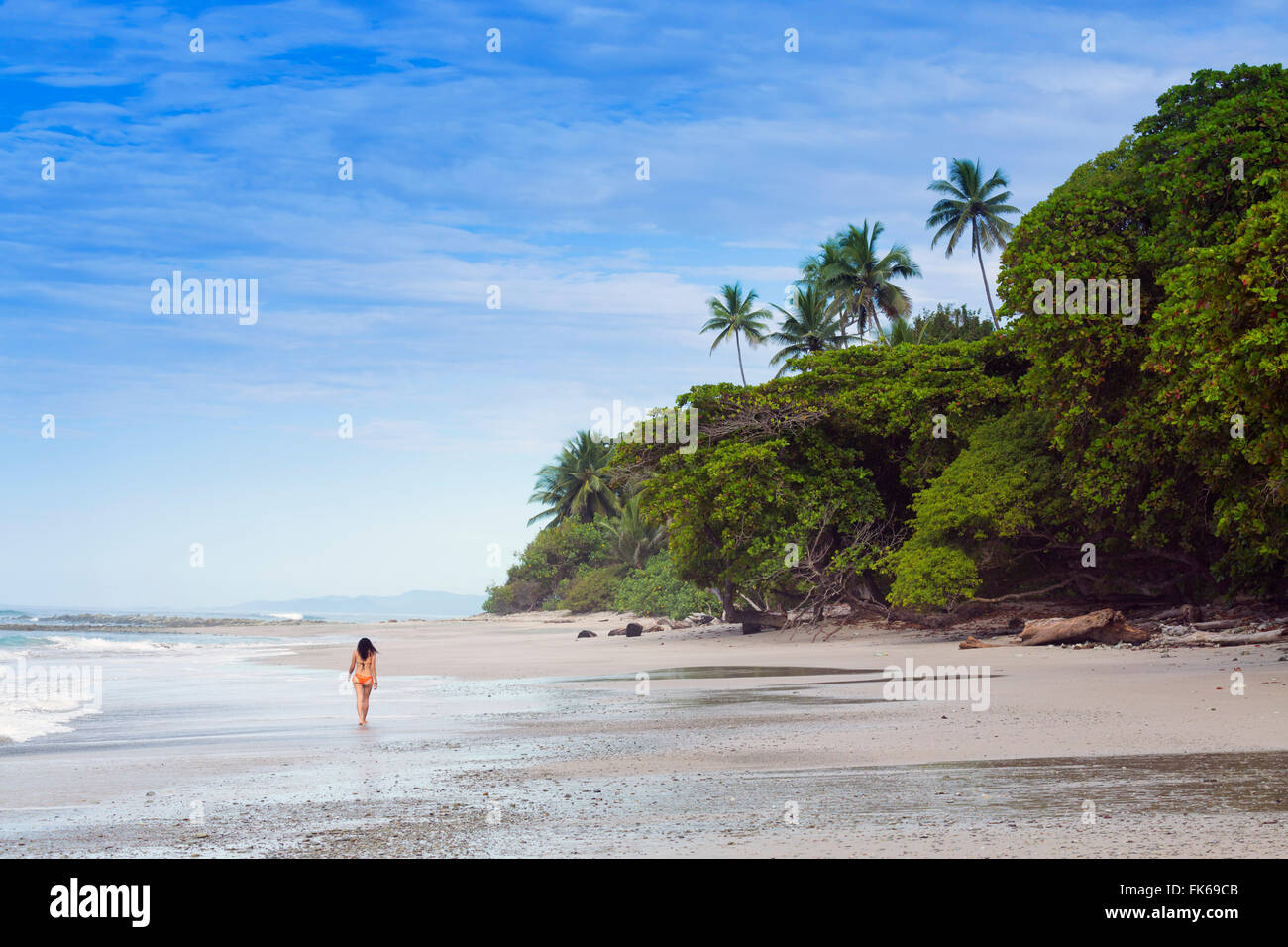 Una giovane donna a piedi lungo la spiaggia di Manzanillo a Santa Teresa, Nicoya peninsula, Puntarenas, Costa Rica, America Centrale Foto Stock
