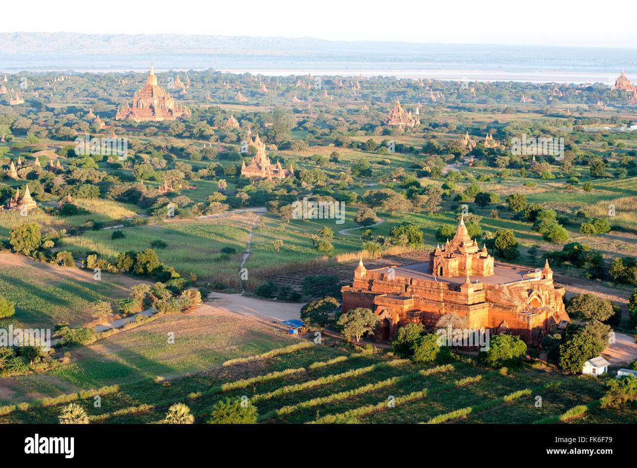 La mattina presto il sole sopra i templi in terracotta di Bagan, il fiume Irrawaddy in distanza, Bagan, Divisione Mandalay Foto Stock