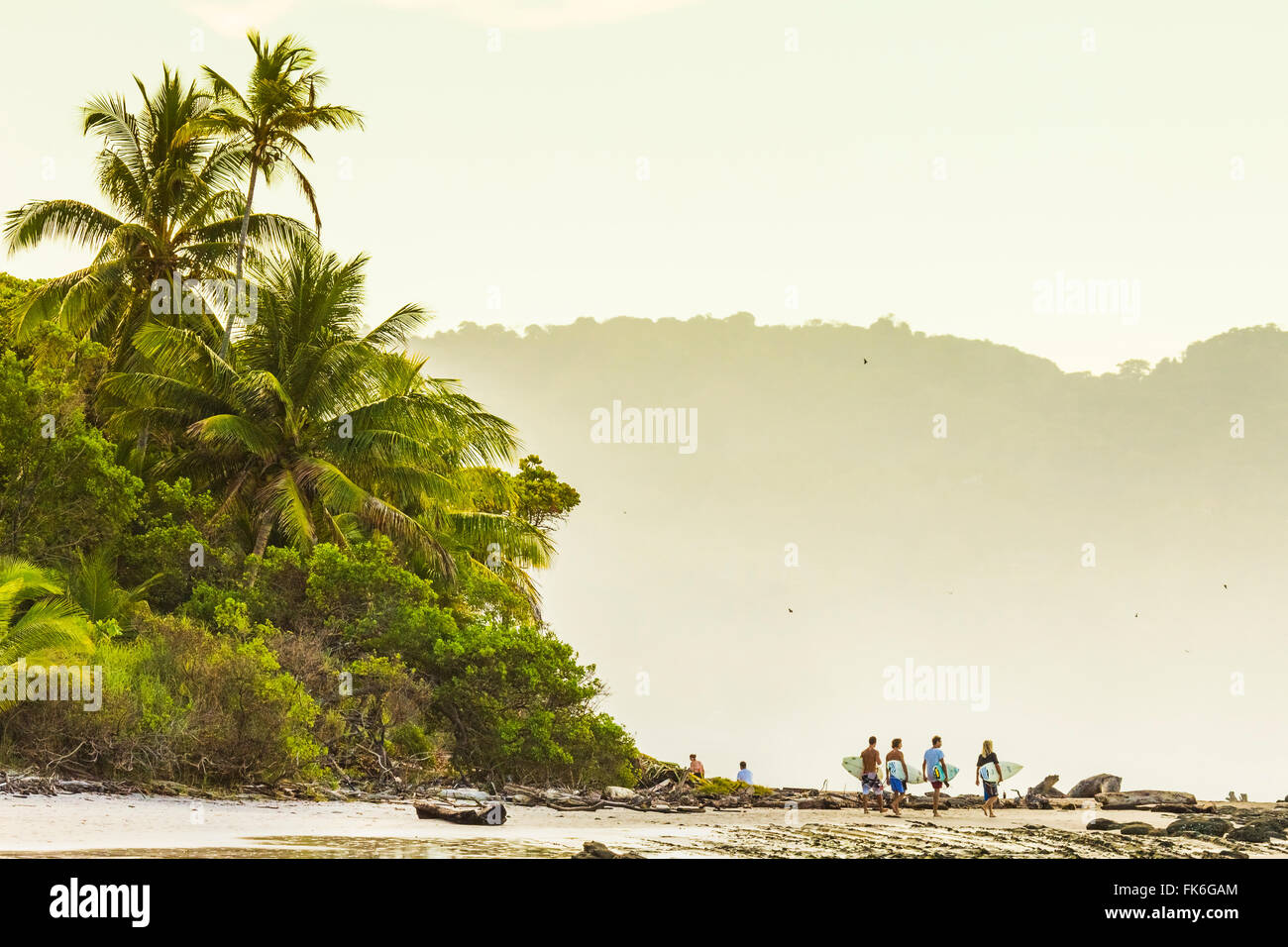 Surfers passeggiare sulla spiaggia di questo anca sud della penisola di Nicoya surf resort, Santa Teresa, Puntarenas, Costa Rica Foto Stock